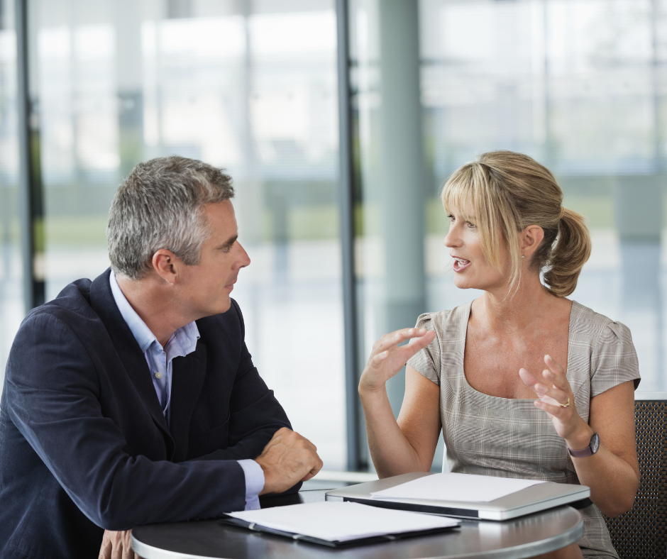 Two people sat at a desk discussing career transition